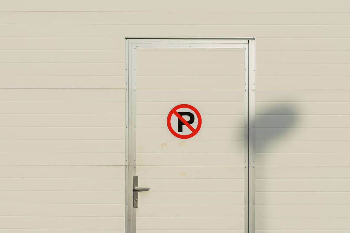 A parking restriction sign fixed to a door, the kind of notice an operator has to be able to prove was in place on a given day.